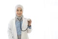 Portrait of Asian muslim female doctor showing stethoscope to camera on white background Royalty Free Stock Photo