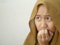 Portrait of Asian muslim teenage girl wearing hijab looked worried and afraid of something bad, biting her nails Royalty Free Stock Photo