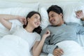 Portrait of Asian new marriage couple lying on bed and look each other. Attractive beautiful young man and woman in pajamas enjoy Royalty Free Stock Photo