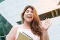 Portrait of Asian pretty laughing face fat woman pose and holding booklet.