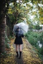 Portrait of Asian school girl walking with umbrella at nature walkway Royalty Free Stock Photo