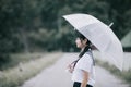 Portrait of Asian school girl walking with umbrella at nature walkway on raining Royalty Free Stock Photo