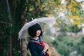 Portrait of Asian school girl walking with umbrella at nature walkway Royalty Free Stock Photo