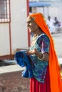 Portrait of Asian senior beautiful woman smiling wearing traditional orange and blue Indian dress sari. Royalty Free Stock Photo