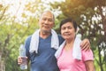 Portrait of Asian Senior couple in blue and pink shirt smiling and standing at park outdoor