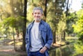 portrait asian senior man with grey hair and beard standing in the forest park Royalty Free Stock Photo