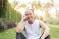 Portrait of Asian senior man relaxing and sitting on grass at th Royalty Free Stock Photo