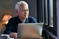 Portrait of Asian senior man using laptop computer and looking out Royalty Free Stock Photo