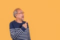 Portrait of Asian senior man wearing glasses standing excited facial expression and pointing finger up into empty blank isolated Royalty Free Stock Photo