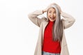 Portrait of asian senior woman, middle-aged lady panic, screaming and looking troubled, concerned, standing over white Royalty Free Stock Photo