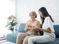 Portrait of Asian senior woman grey short hair holds pill and a glass of drinking water from young adult daughter. Royalty Free Stock Photo