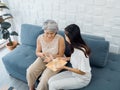 Portrait of Asian senior woman grey short hair holds pill and a glass of drinking water from young adult daughter. Royalty Free Stock Photo