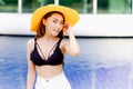 portrait asia sexy woman at swimming pool wearing black lingerie and white short with yellow sombrero hat, fashion in summer Royalty Free Stock Photo