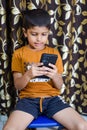 Portrait of Asian smart happy little boy using Mobile phone at home. Little boy holding mobile smart phone, online back to school Royalty Free Stock Photo