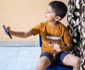 Portrait of Asian smart happy little boy using Mobile phone at home. Little boy holding mobile smart phone, online back to school Royalty Free Stock Photo