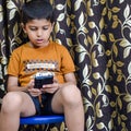 Portrait of Asian smart happy little boy using Mobile phone at home. Little boy holding mobile smart phone, online back to school Royalty Free Stock Photo