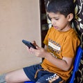 Portrait of Asian smart happy little boy using Mobile phone at home. Little boy holding mobile smart phone, online back to school Royalty Free Stock Photo