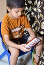 Portrait of Asian smart happy little boy using Mobile phone at home. Little boy holding mobile smart phone, online back to school Royalty Free Stock Photo