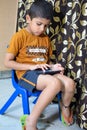 Portrait of Asian smart happy little boy using Mobile phone at home. Little boy holding mobile smart phone, online back to school Royalty Free Stock Photo