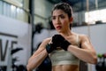 Portrait of Asian sport woman clenched fist and look forward with serious and spirited also stand in fitness gym