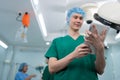 Portrait of Asian surgeon with medical mask standing and holding a tablet in operation theater at a hospital. Team of Professional Royalty Free Stock Photo