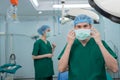 Portrait of Asian surgeon with medical mask standing in operation theater at a hospital. Team of Professional surgeons. Healthcare Royalty Free Stock Photo