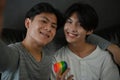 Portrait of an Asian teen gay couple holding a rainbow heart. LGBT pride love symbol