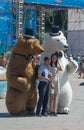 Portrait of Asian tourists on the background of people dressed in costumes of tall bears.