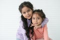 Portrait of Asian two sisters, 6 year and 3 year old, in casual clothes with black long hairs. Cute little girl smiling embracing Royalty Free Stock Photo