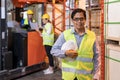 Portrait of asian warehouse manager with warehouse worker in background