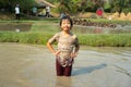 Portrait Asian wet girl enjoys plays in the mud pond and chases group of ducks in the farm