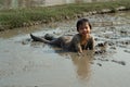 Portrait Asian wet girl enjoys plays in the mud pond and chases group of ducks in the farm