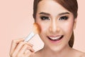 Portrait of a asian woman applying dry cosmetic tonal foundation on the face using makeup brush Royalty Free Stock Photo