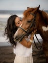 Portrait of Asian woman and brown horse. Woman kissing horse. Romantic concept. Love to animals. Nature concept. Bali