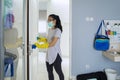 Asian woman cleaning door handle with disinfectant