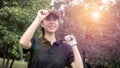 Portrait of a Asian woman golfer in black T-shirt with a golf club on a background of golf courses Royalty Free Stock Photo
