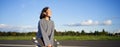 Portrait of asian woman with longboard. Korean girl skating, holding skateboard in hands, posing on road, smiling and Royalty Free Stock Photo