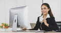 Portrait asian woman office people sitting at working desk and computer on desk while smiling holding coffee cup and look at Royalty Free Stock Photo