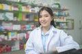 Portrait of asian woman pharmacist wearing lab coat in a modern pharmacy drugstore Royalty Free Stock Photo