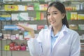 Portrait of asian woman pharmacist wearing lab coat in a modern pharmacy drugstore Royalty Free Stock Photo