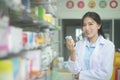 Portrait of asian woman pharmacist wearing lab coat in a modern pharmacy drugstore Royalty Free Stock Photo