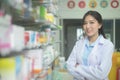 Portrait of asian woman pharmacist wearing lab coat in a modern pharmacy drugstore Royalty Free Stock Photo