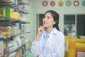 Portrait of asian woman pharmacist wearing lab coat in a modern pharmacy drugstore Royalty Free Stock Photo