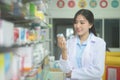 Portrait of asian woman pharmacist wearing lab coat in a modern pharmacy drugstore Royalty Free Stock Photo