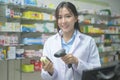 Portrait of asian woman pharmacist wearing lab coat in a modern pharmacy drugstore Royalty Free Stock Photo