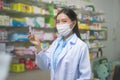 Portrait of asian woman pharmacist wearing a surgical mask in a modern pharmacy drugstore, covid-19 and pandemic concept Royalty Free Stock Photo