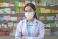 Portrait of asian woman pharmacist wearing a surgical mask in a modern pharmacy drugstore, covid-19 and pandemic concept Royalty Free Stock Photo