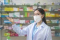 Portrait of asian woman pharmacist wearing a surgical mask in a modern pharmacy drugstore, covid-19 and pandemic concept Royalty Free Stock Photo