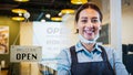 Portrait of Asian woman restaurant or coffee shop owner smile, hanging open sign post. Small business entrepreneur