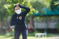Portrait of Asian woman running at village park listening to music and wearing mask